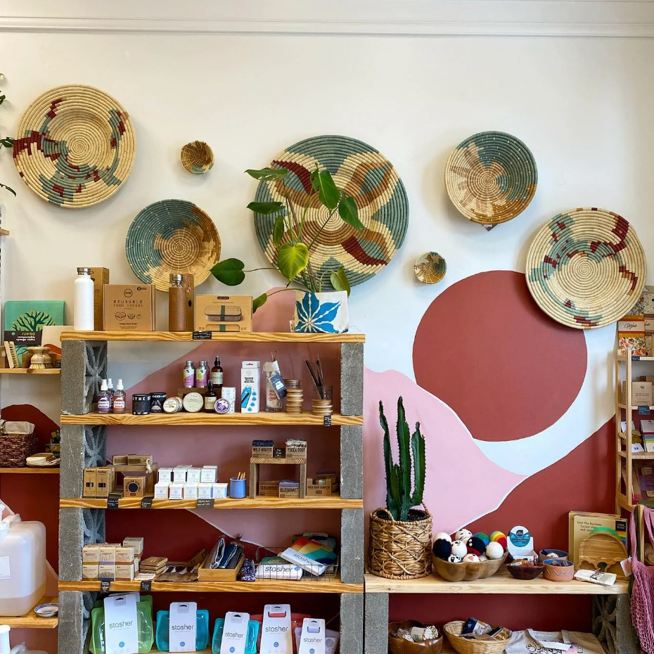 Woven baskets on a wall with shelves displaying various items in a store setting.